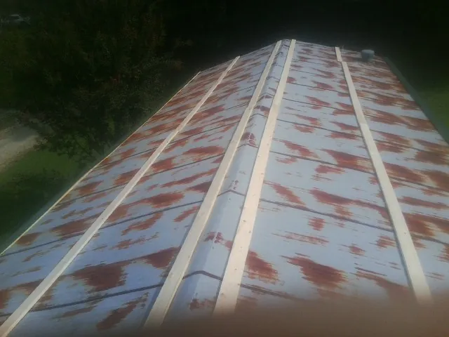 Rusted metal roof panels with new wood purlins before replacement — Storm Damage Roof Repair in Margarettsville by Roofing Brothers