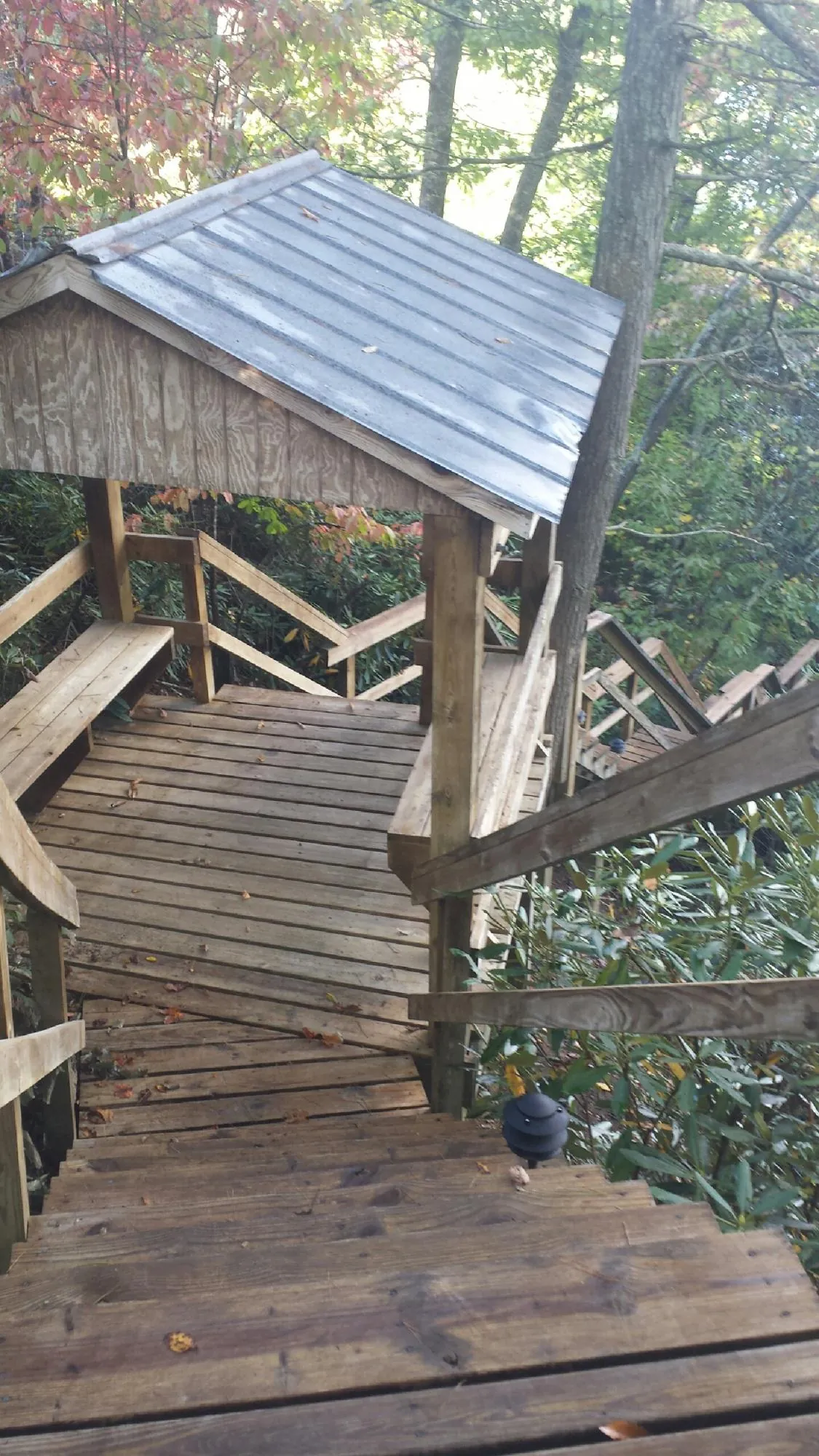 Metal roofed shelter over wooden steps on a wooded walkway — Skylight Repair & Installation work by our crew in Margarettsville