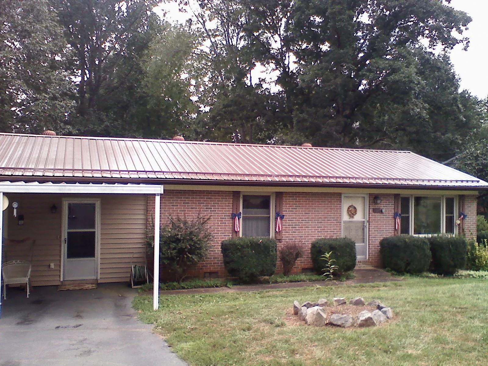 Bronze metal roof and carport on a brick ranch home — Roof Repair work by our crew in Margarettsville
